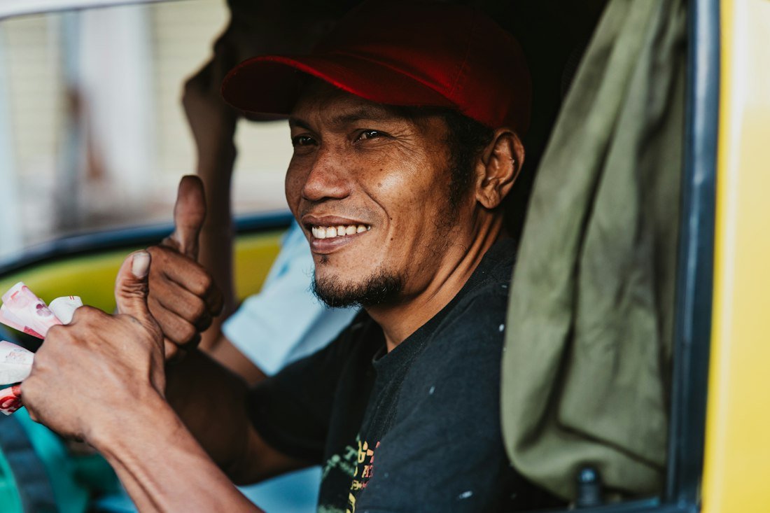 A driver smiling in the front seat of a car