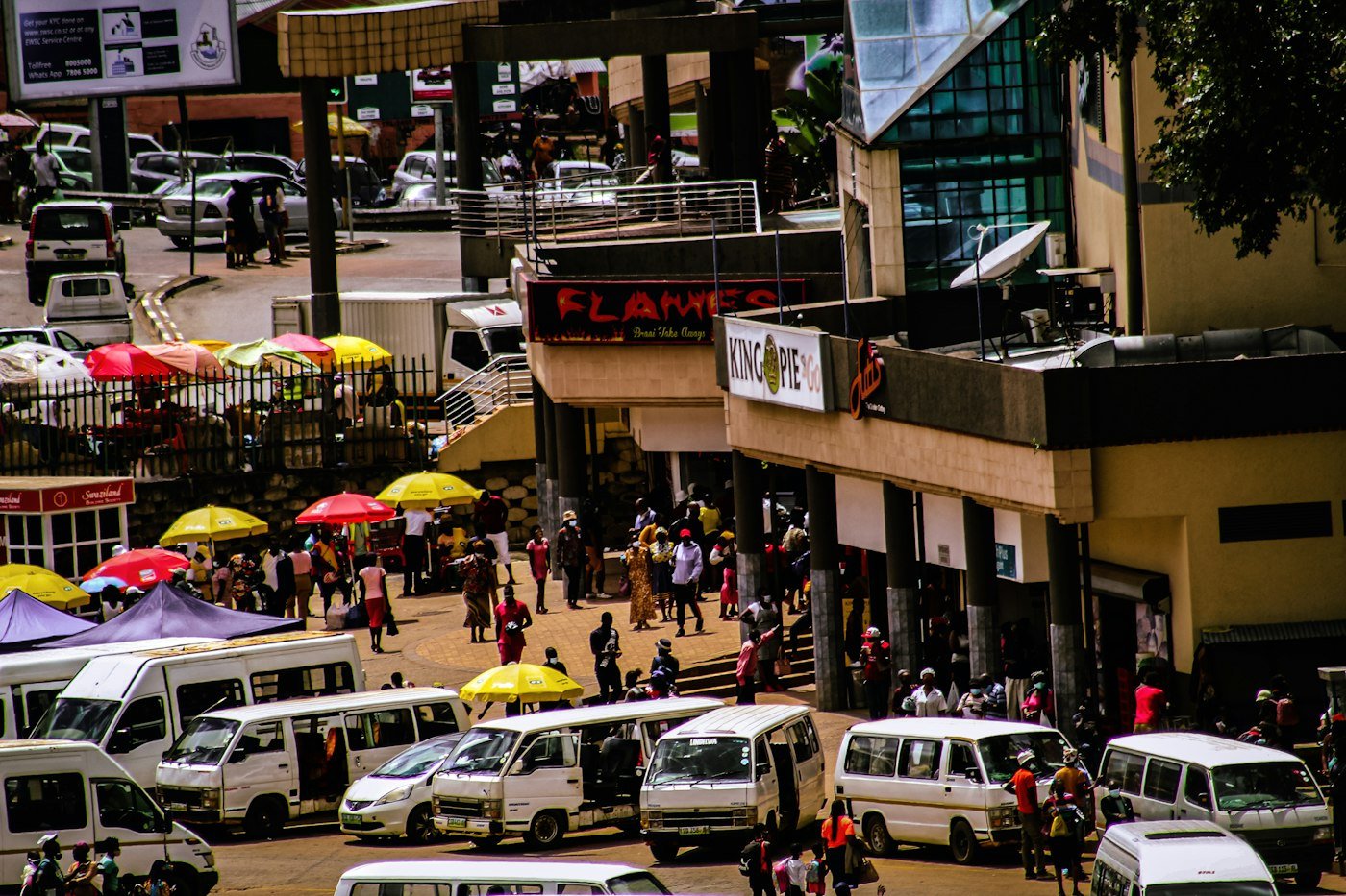 A bustling street market with vans and people
