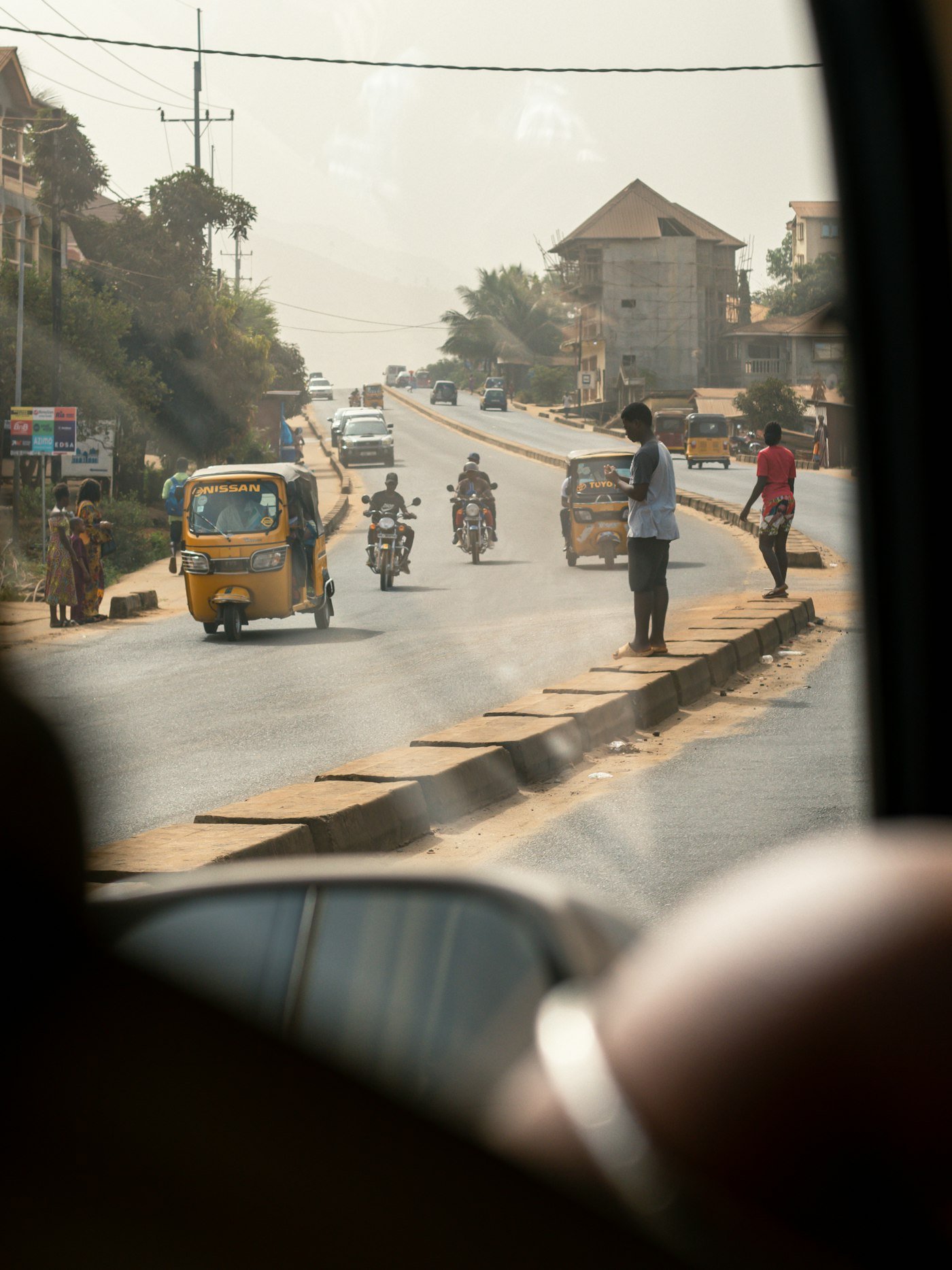 Motorcycles and cars at a busy African intersection