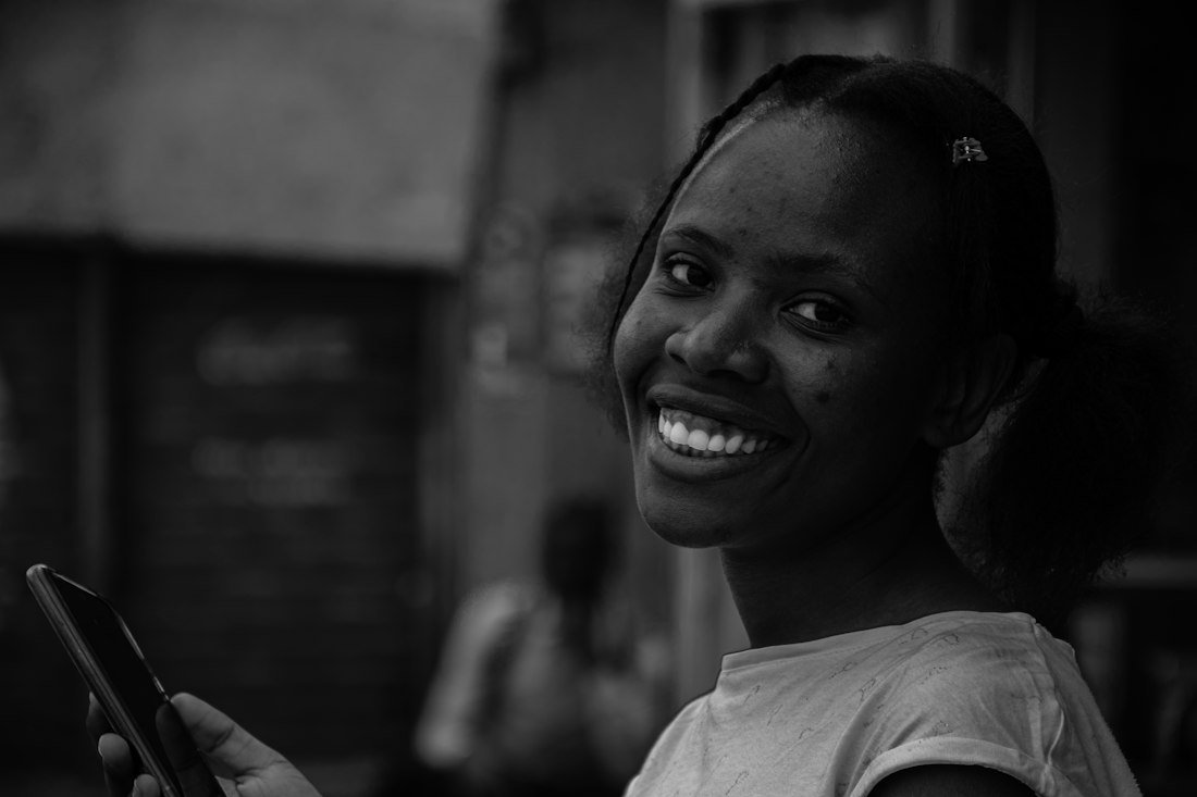 A woman smiling while using her phone
